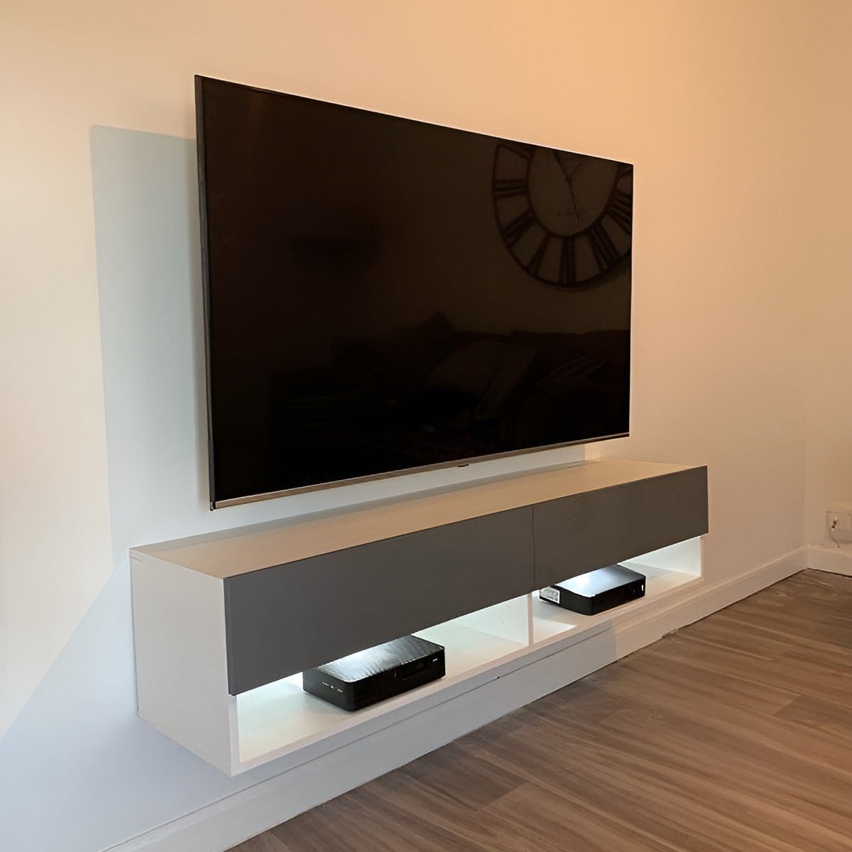 Modern TV stand with a television mounted on a wall in a room.