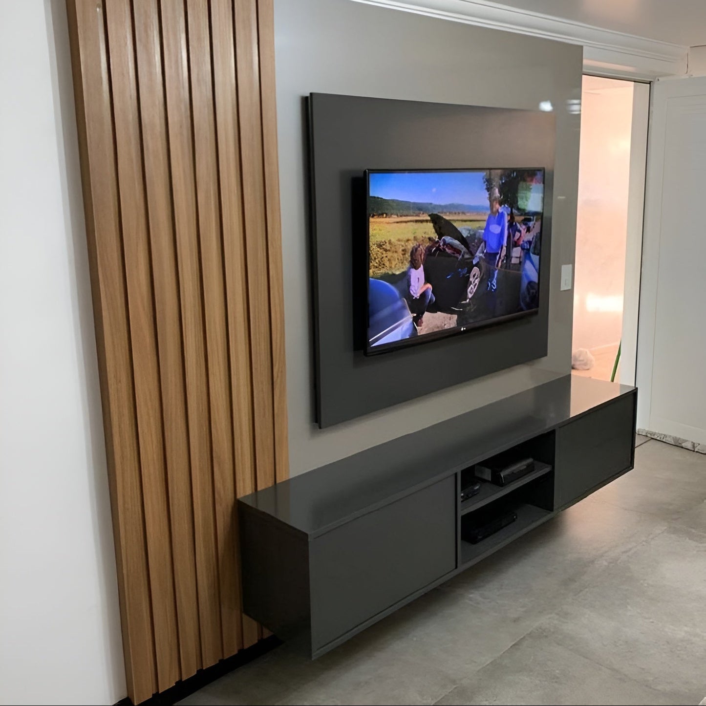 Modern living room with a television mounted on the wall and a dark entertainment console.