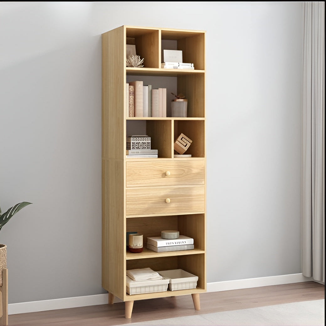 Wooden bookshelf with shelves and a drawer against a gray wall.