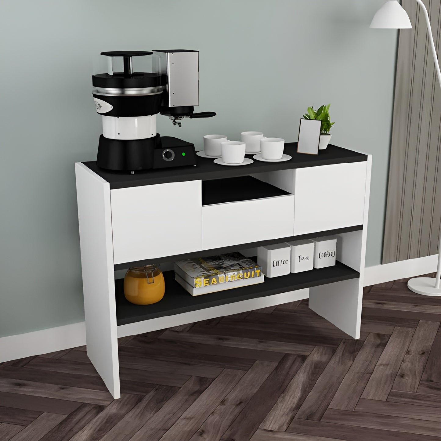 Coffee-making station on a white and black console table in a room with wooden flooring.