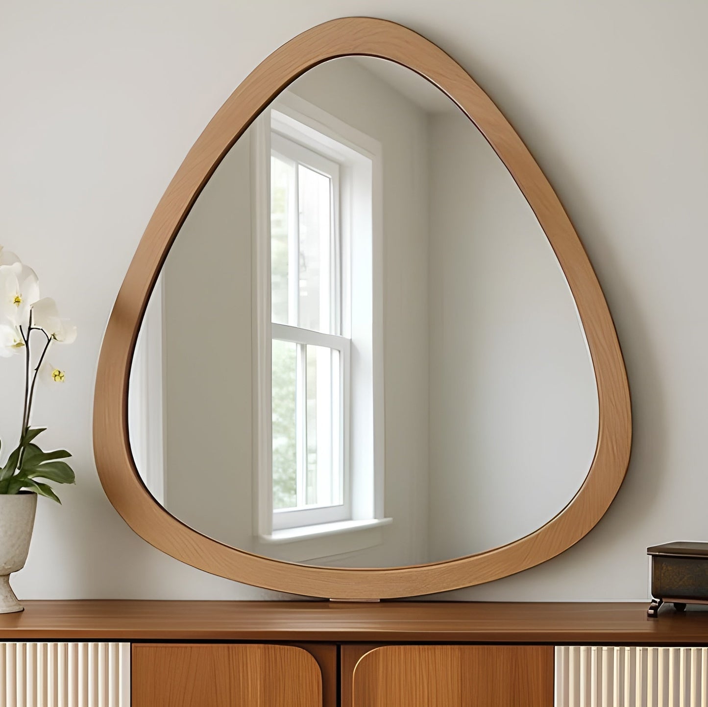 Wooden-framed mirror on a wooden console table with a light background