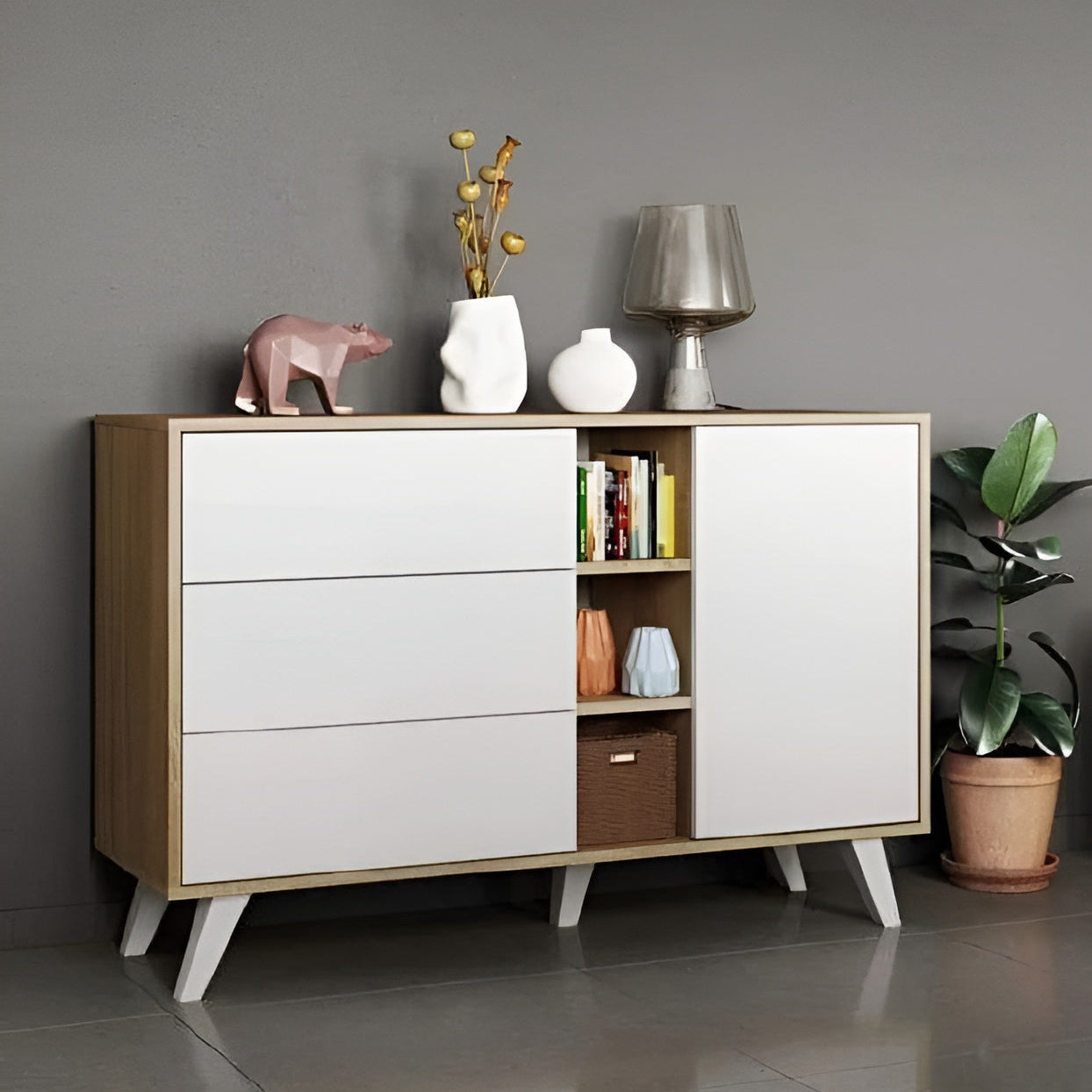 Wooden sideboard with white doors and drawers against a gray wall.