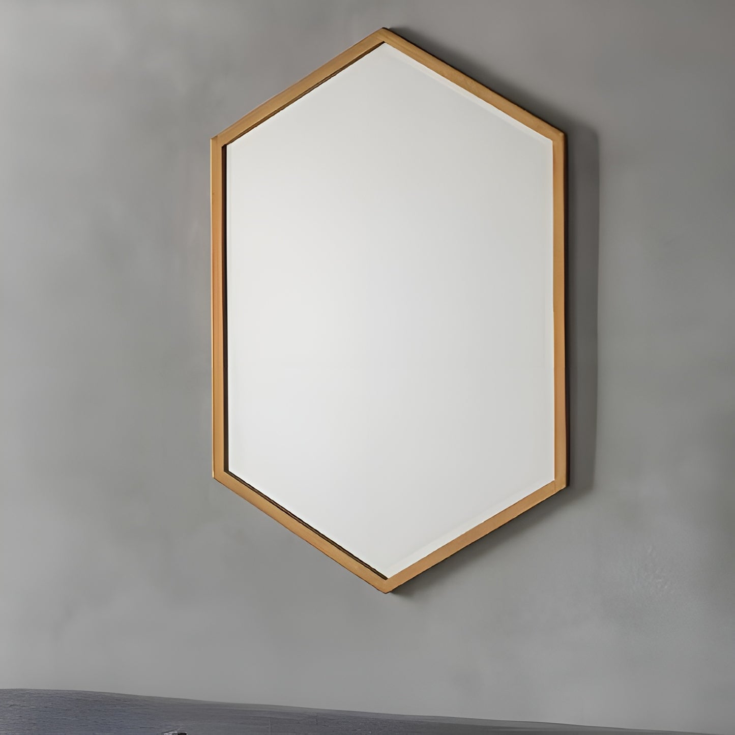 Hexagonal mirror with wooden frame on a gray wall