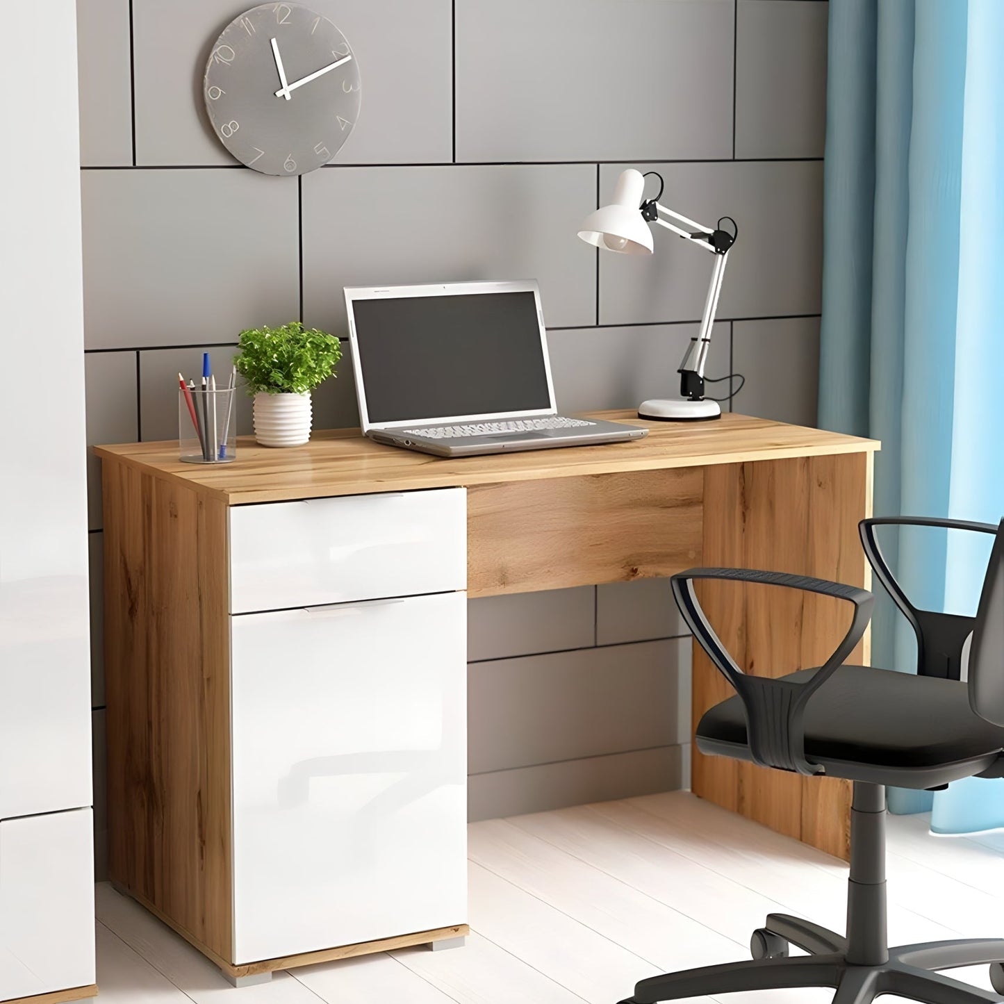 Modern office desk with laptop, lamp, and decor in a room with gray tiled wall and blue curtains.
