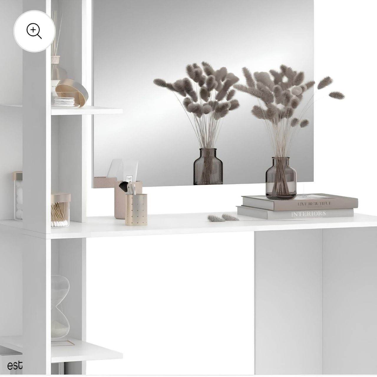 Decorative setup with vases, books, and a mirror on a white surface.