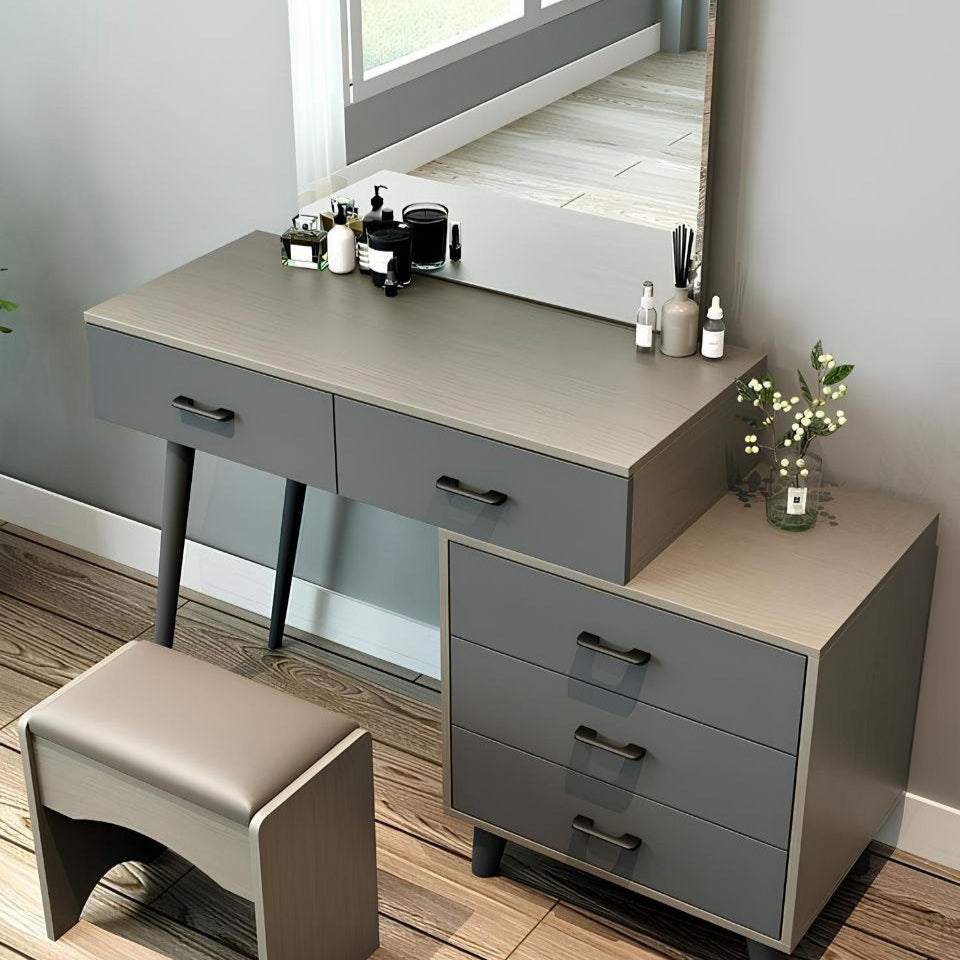 Gray vanity desk with mirror, drawers, and stool in a room setting.