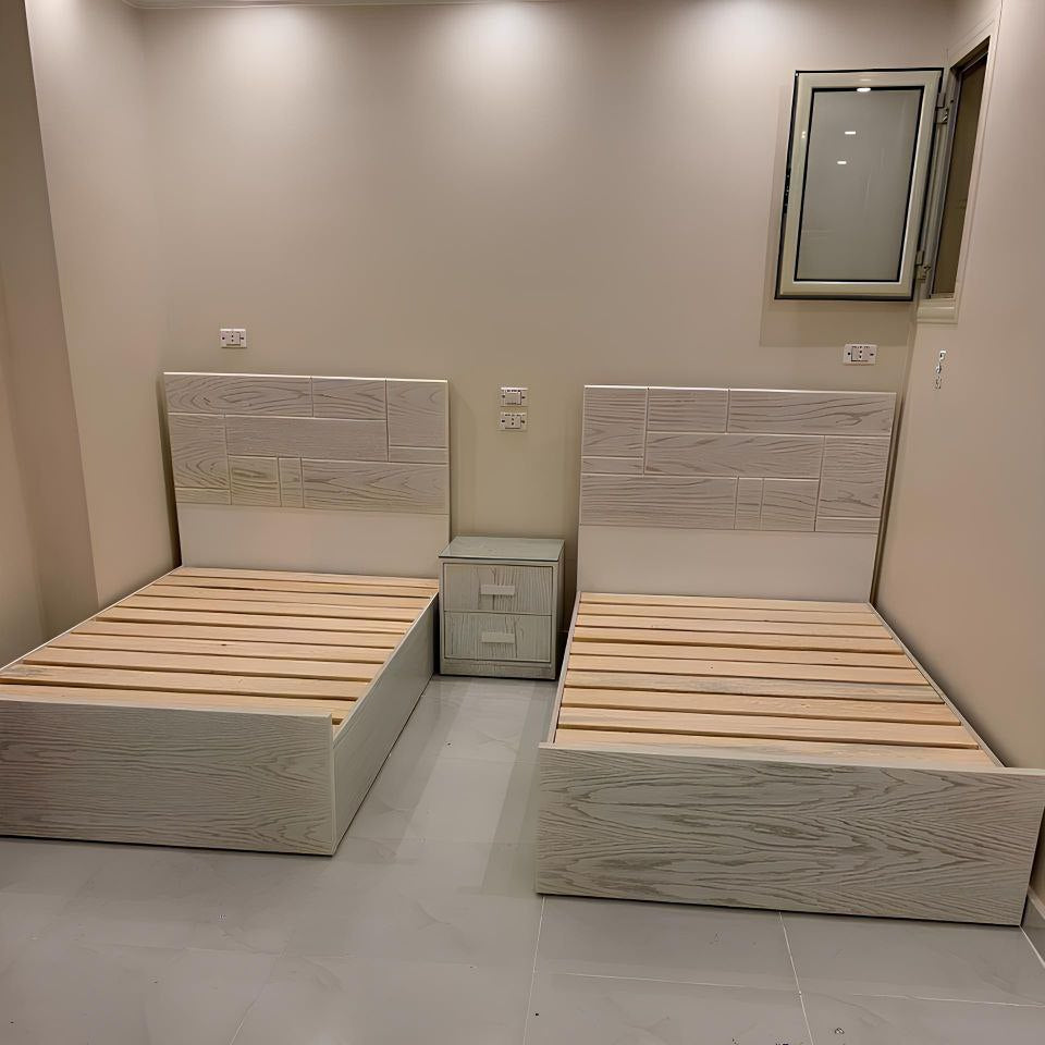 Two wooden beds with white frames in a room with tiled floor and beige walls.