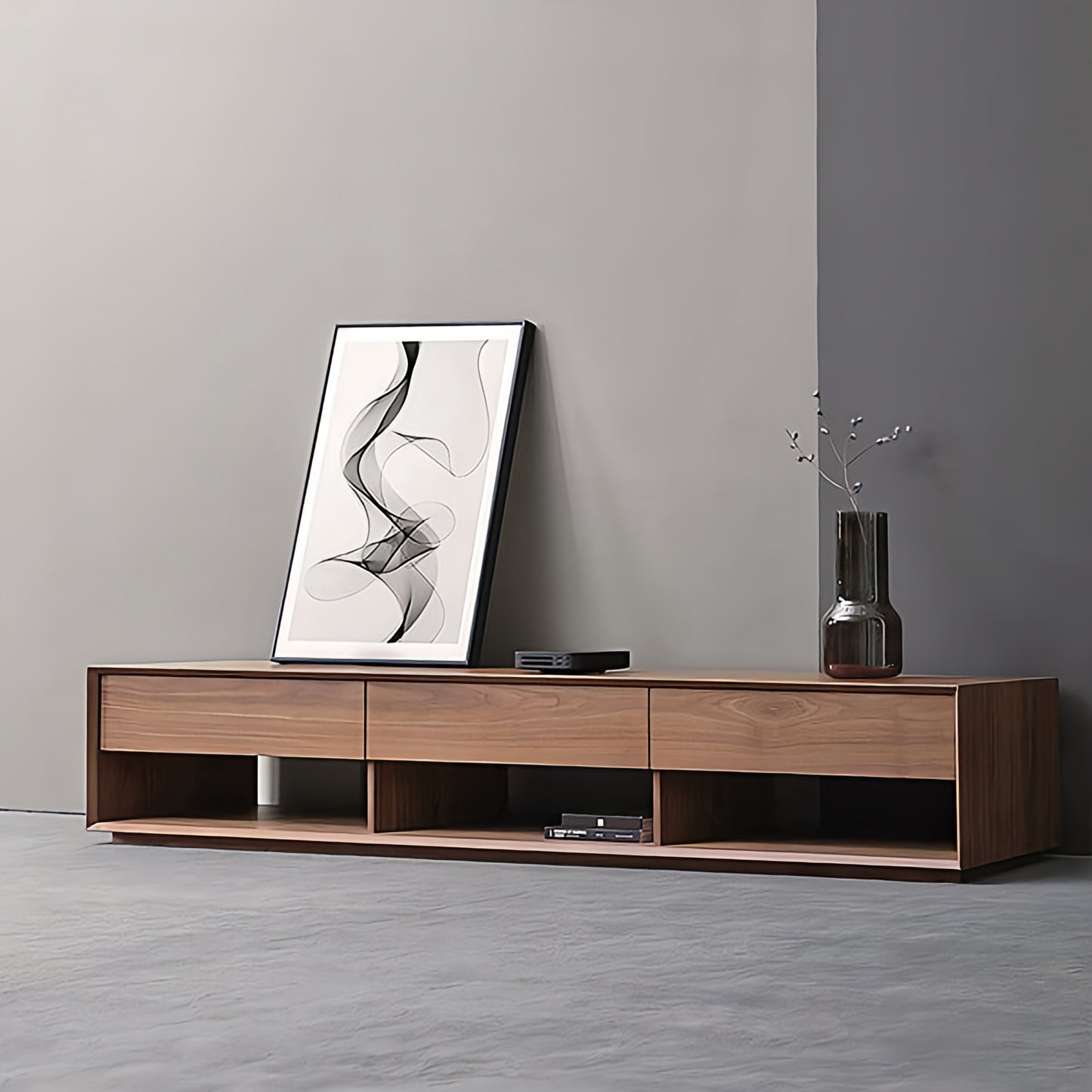 Wooden TV stand with a vase and abstract art against a gray wall.
