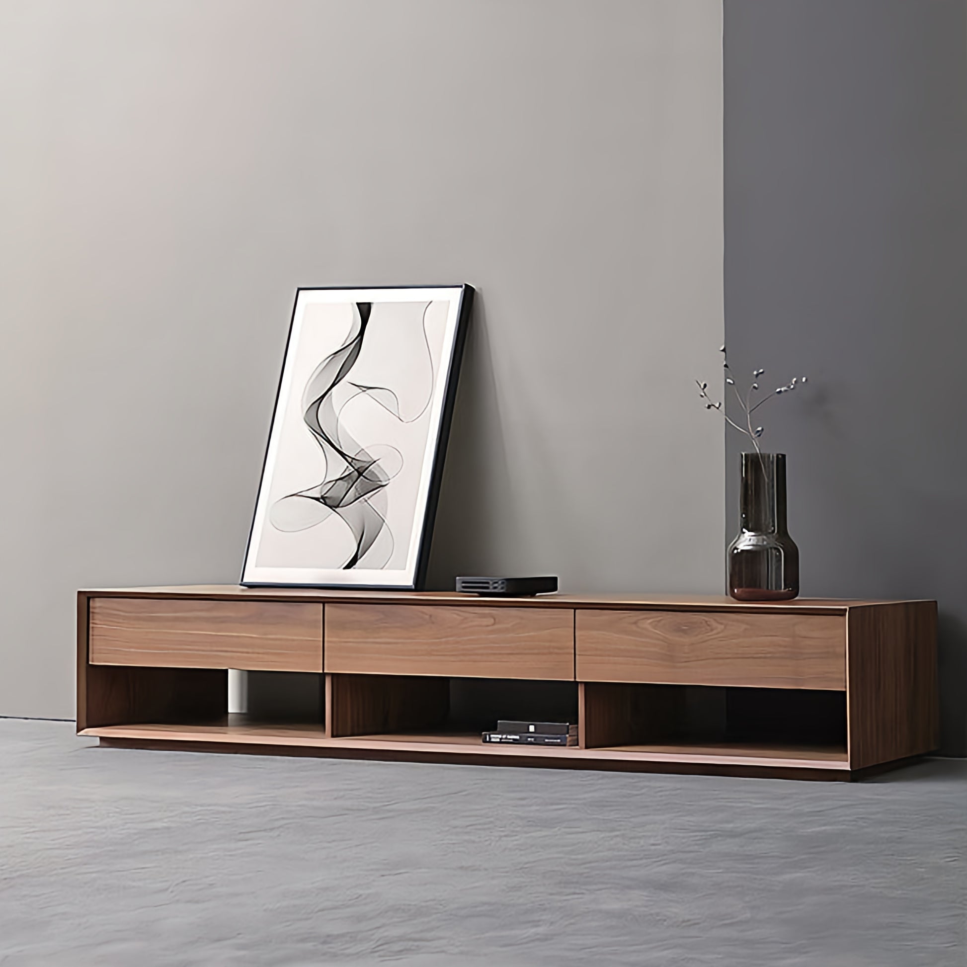 Wooden TV stand with a vase and abstract art against a gray wall.