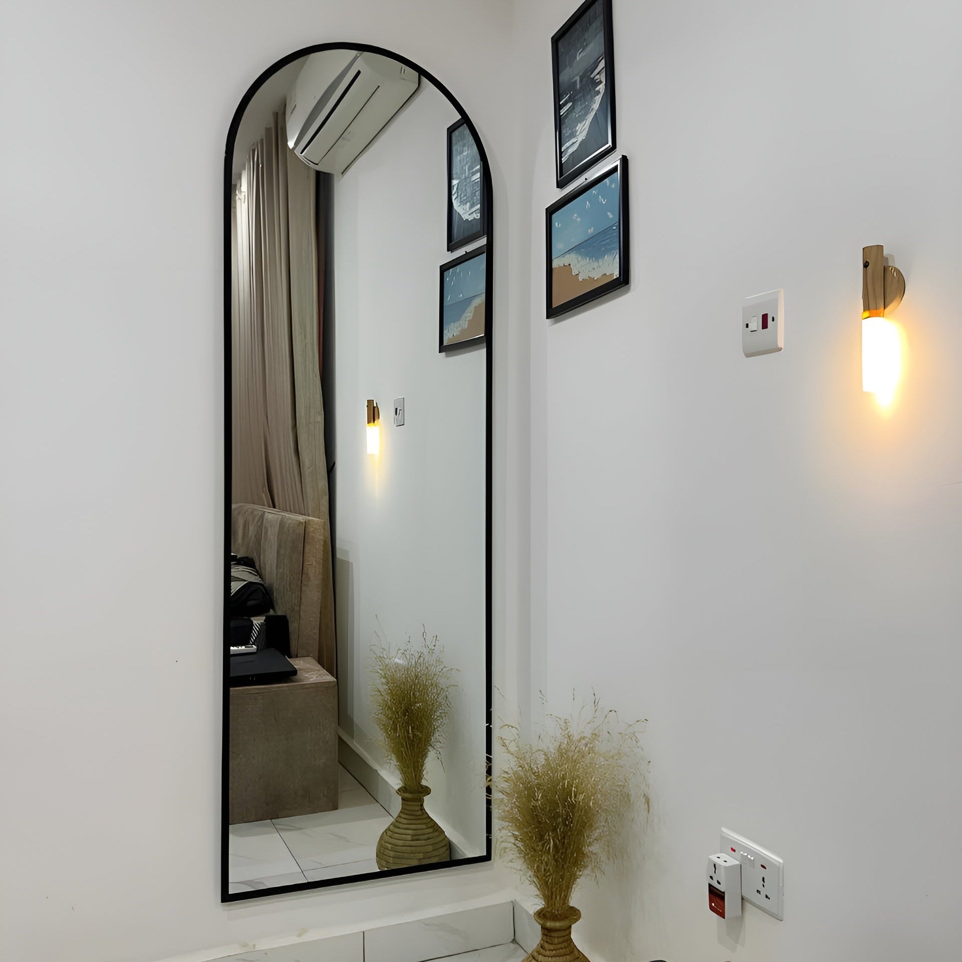 Full-length mirror in a room with wall lights and decor