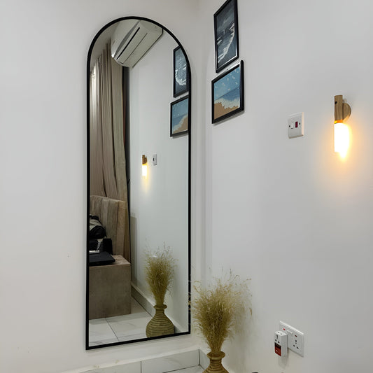 Full-length mirror in a room with wall lights and decor