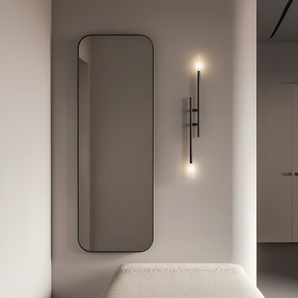 Modern interior with a tall mirror, wall-mounted light fixture, and textured bench.