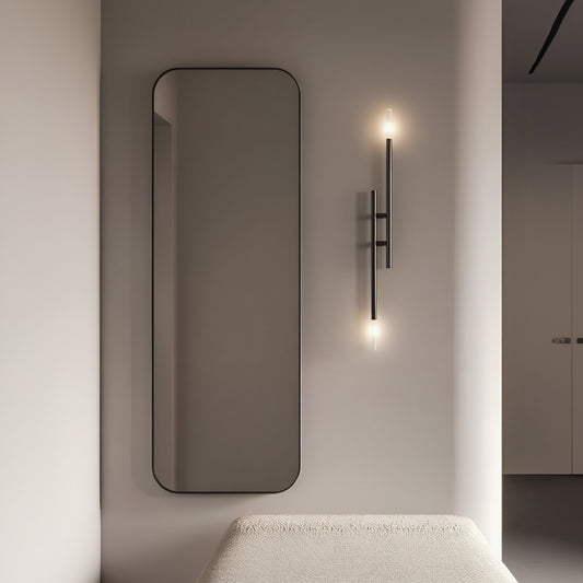 Modern interior with a tall mirror, wall-mounted light fixture, and textured bench.