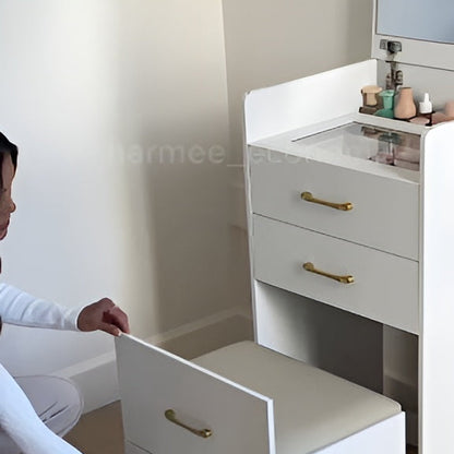 Person opening a white drawer with gold handles in a bathroom setting.