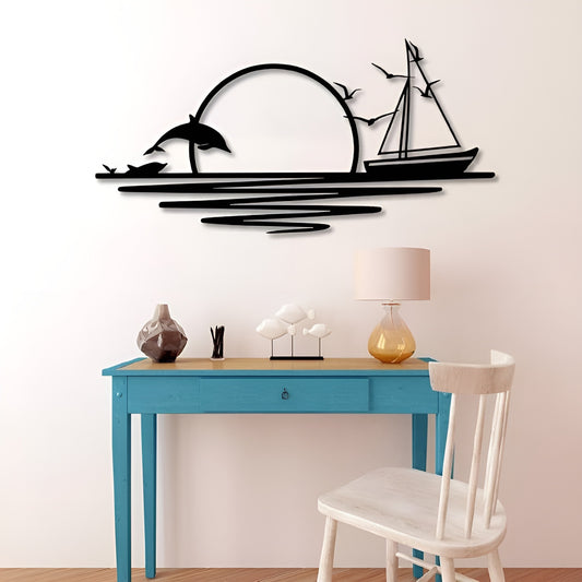 Decorative wall art with dolphins and a sailboat above a desk and chair.