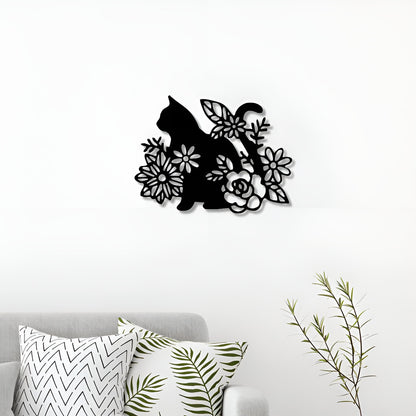 Decorative wall art of a cat among flowers on a white wall above a sofa with patterned cushions.