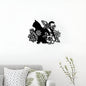 Decorative wall art of a cat among flowers on a white wall above a sofa with patterned cushions.