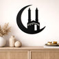 Decorative wall art of a crescent moon with a building silhouette on a beige wall above a wooden cabinet.