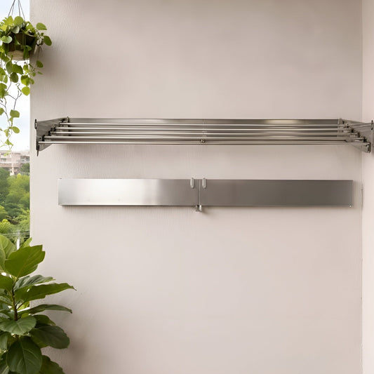 Stainless steel range hood mounted on a white wall with potted plants below.