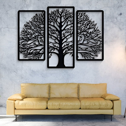 Three black tree-shaped wall art pieces on a gray wall above a yellow sofa.