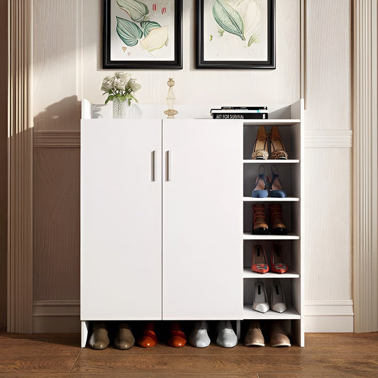 White shoe cabinet with shoes on a wooden floor in a room with framed artwork on the wall.