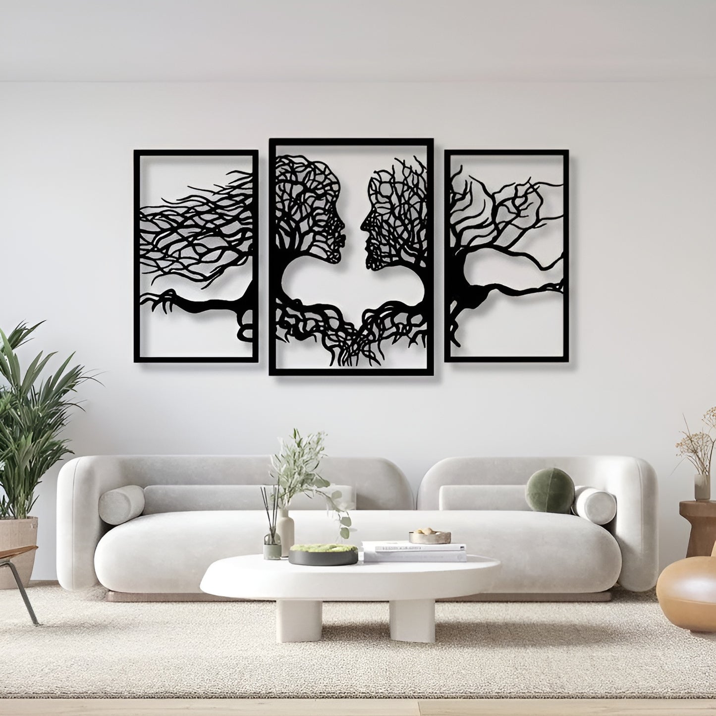 Three black and white wall art pieces on a white wall above a modern white sofa.