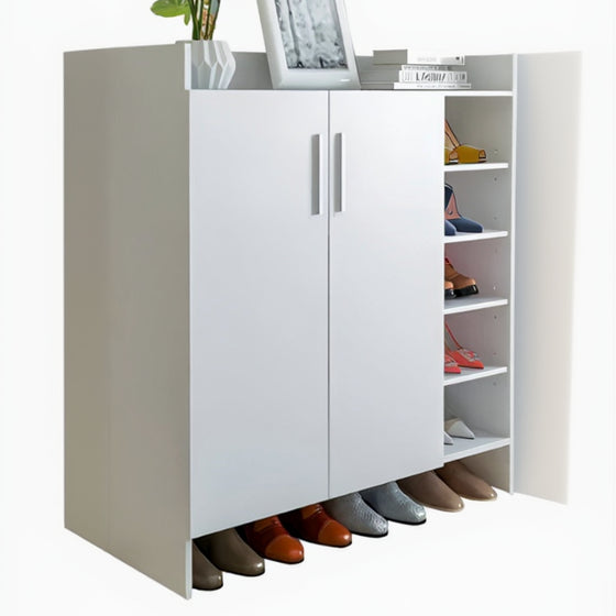 White shoe cabinet with shoes underneath, a plant on top, and a picture frame.
