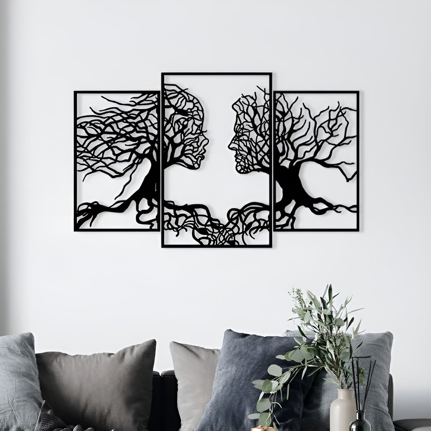 Three black and white abstract wall art pieces on a white wall above a sofa.