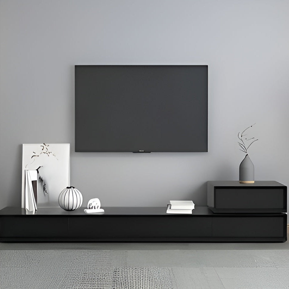 Modern living room with a black TV mounted on a gray wall, featuring a black entertainment console with decorative items.
