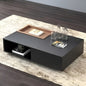 Modern black coffee table with decorative items on a wooden floor.