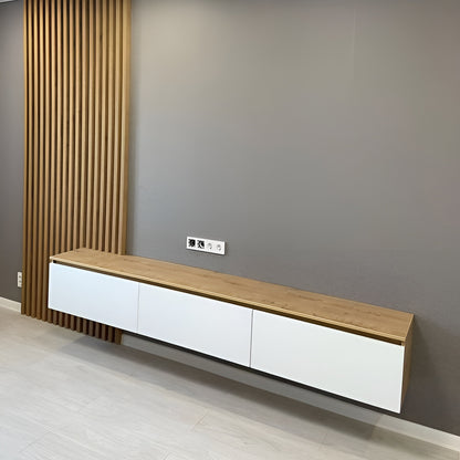Long wooden and white cabinet against a gray wall with a curtain.