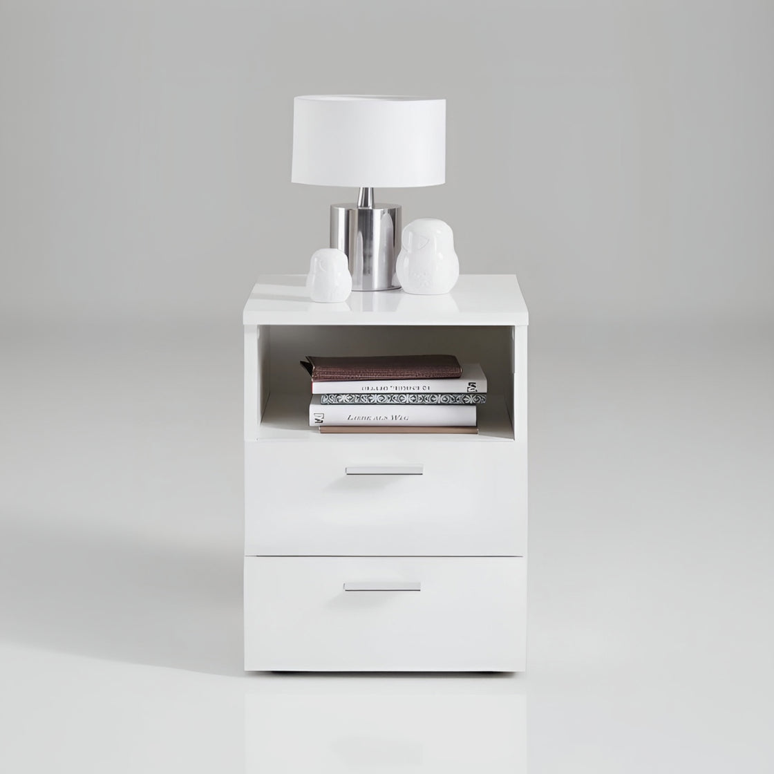 White nightstand with a lamp and books on a gray background