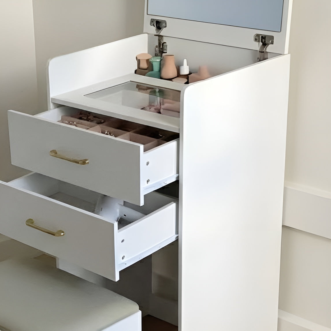 White vanity with open drawers and a mirror above, featuring various items on the counter.