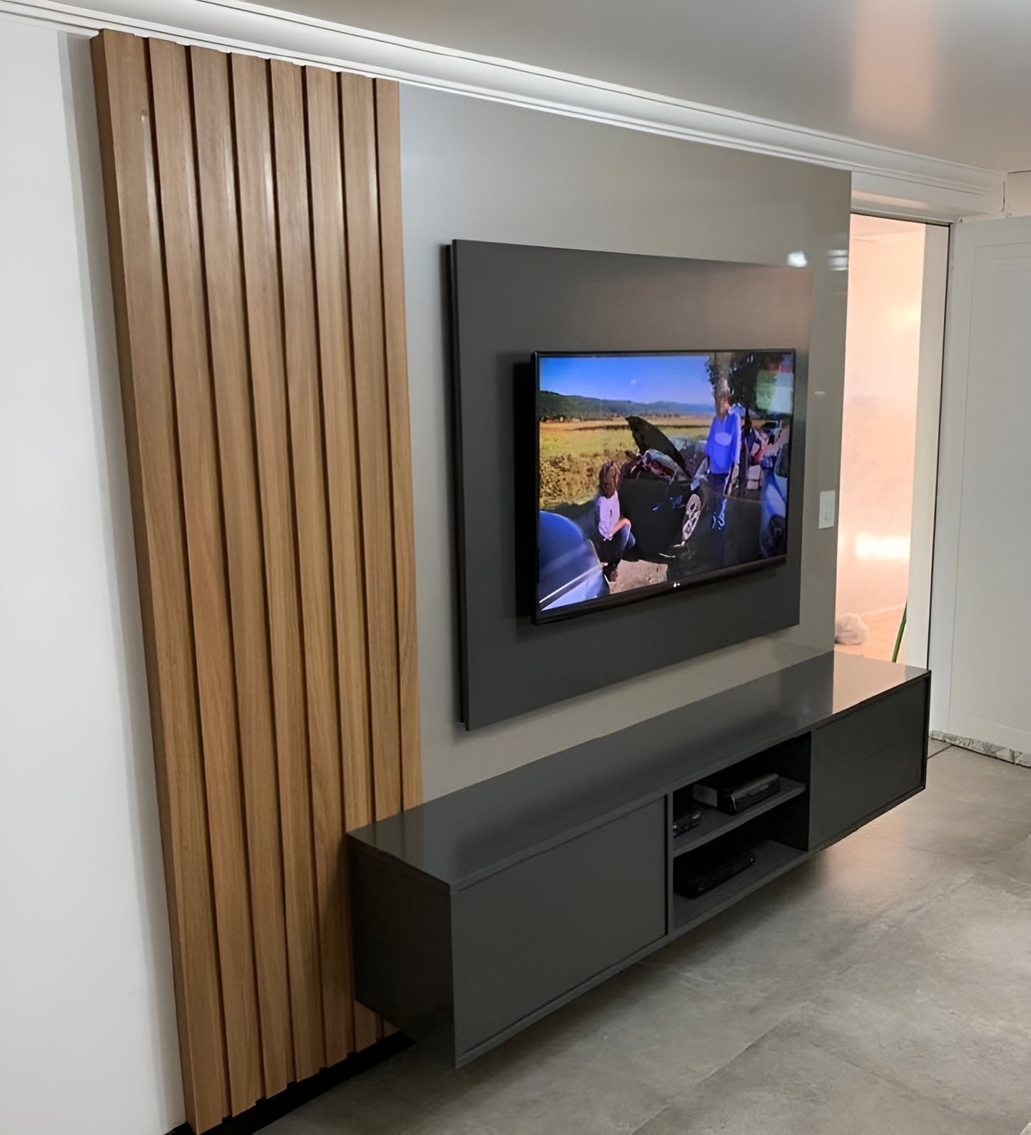 Modern living room with a television mounted on the wall and a dark entertainment console.