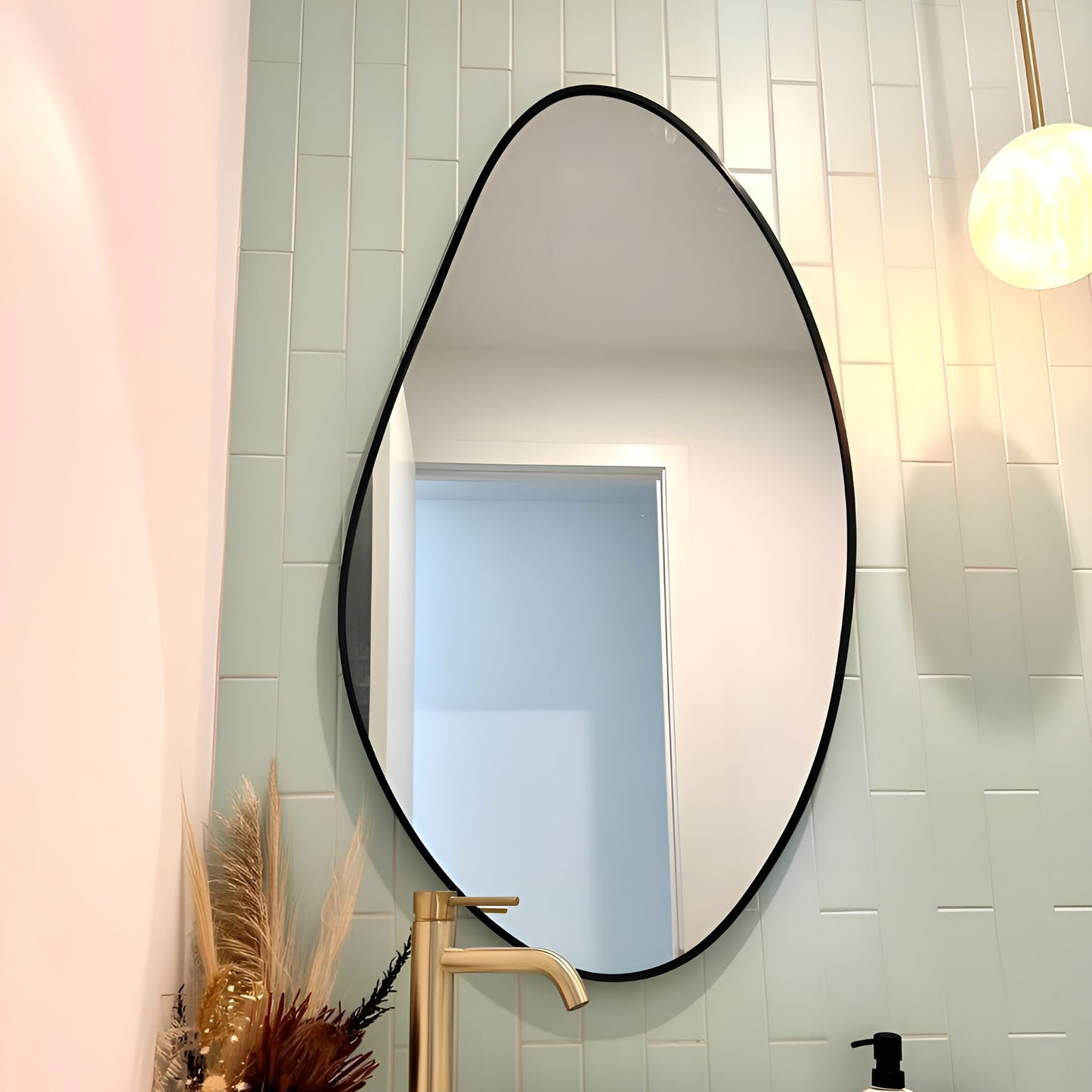 Bathroom with a large oval mirror, white sink, and decorative elements.