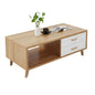 Wooden coffee table with white drawers, decorative items, and a plant on a white background