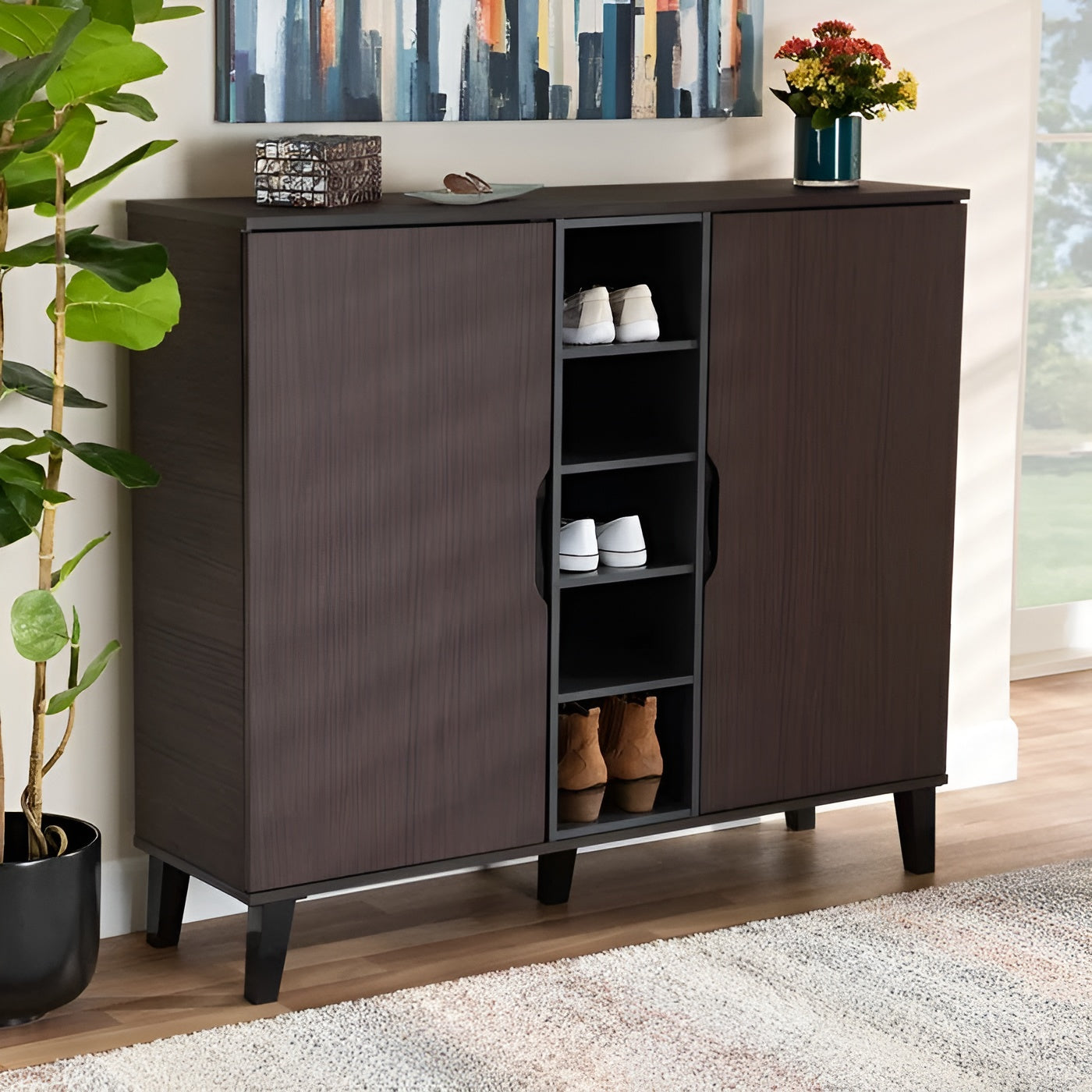 Dark brown shoe cabinet with open doors displaying shoes, placed in a room with a painting and plant.
