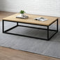 Wooden coffee table with black metal frame on a gray rug