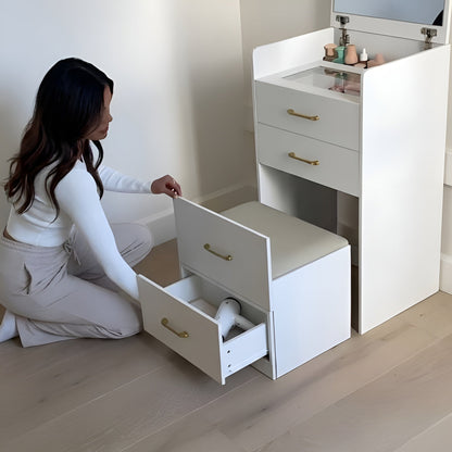 Woman opening a drawer in a white vanity unit with gold handles.