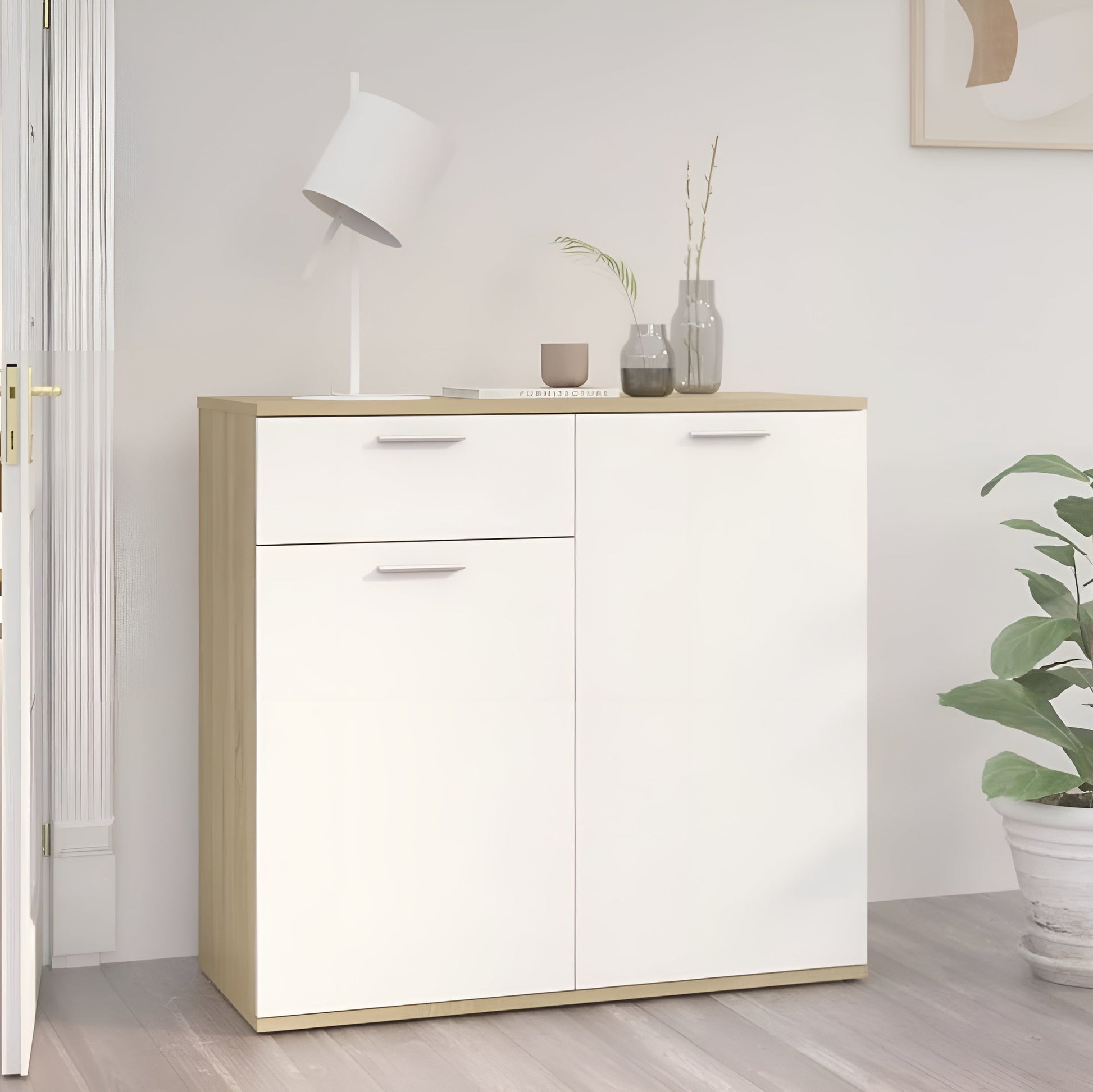 White cabinet with wooden accents in a room with a plant and lamp.