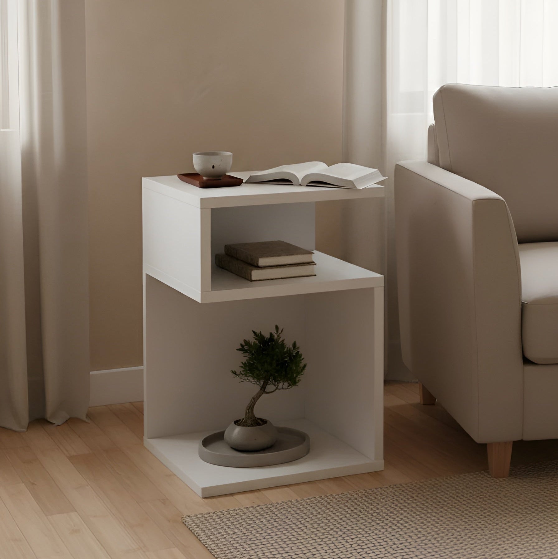 White side table with a plant, books, and a glass in a living room setting.