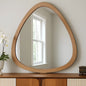 Wooden-framed mirror on a wooden console table with a light background