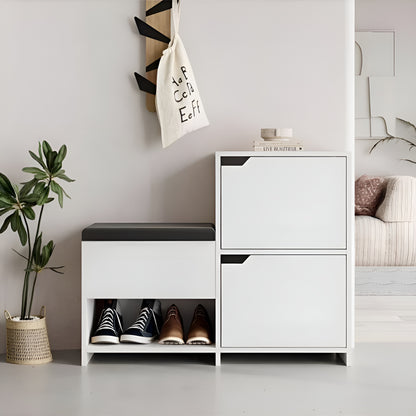 White storage cabinet with shoes underneath, plant to the left, and sofa with decorative pillows in the background.