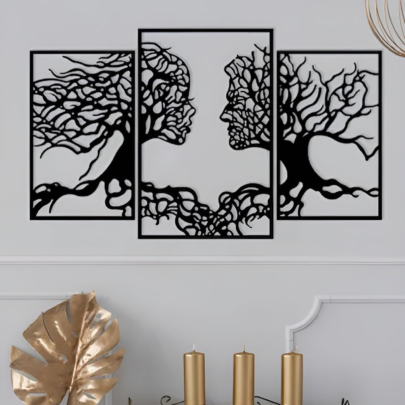 Set of four black tree-shaped wall art pieces on a light gray wall.