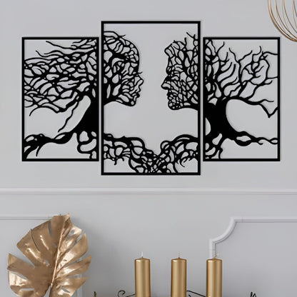 Set of four black tree-shaped wall art pieces on a light gray wall.