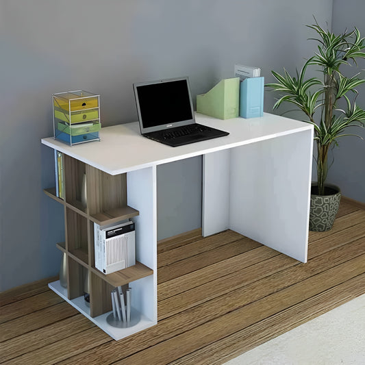 White desk with laptop, books, and a plant in a room with wooden floor and gray walls.