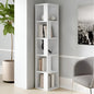 White bookshelf with books and decor items in a room with a plant and wall art.