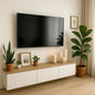 Modern living room with a TV mounted on the wall, a wooden console table with decorative items, and plants.