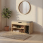 Wooden shoe storage bench with shoes underneath, round mirror above, and plant to the left.