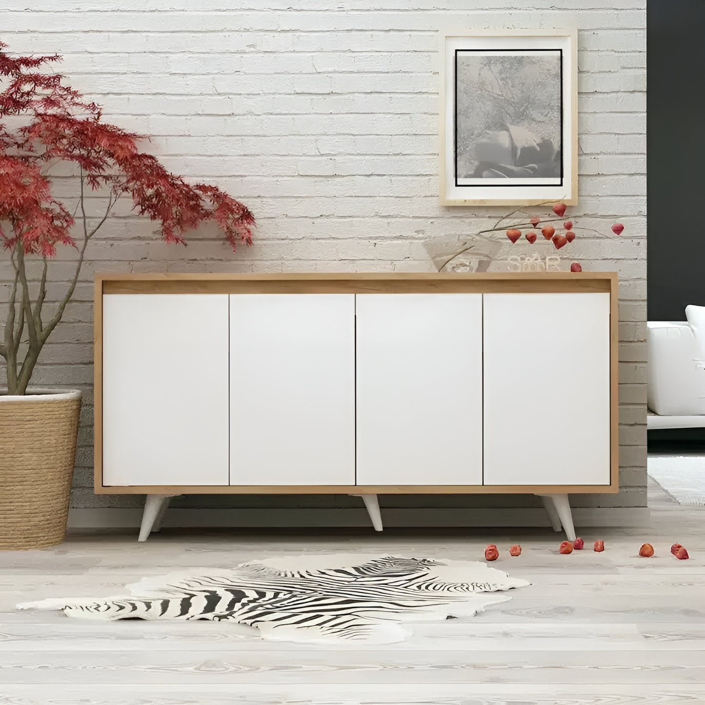 Modern sideboard with wooden frame and white doors in a room with a plant and artwork on the wall.
